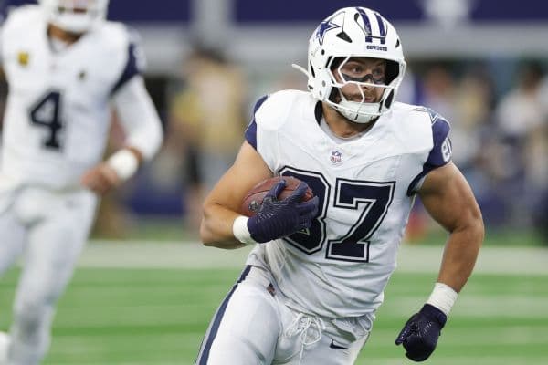 Jake Ferguson #87 of the Dallas Cowboys runs with the ball after a catch during the first quarter against the Washington Commanders at AT&T Stadium on October 19, 2025 in Arlington, Texas.
